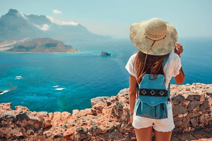 Woman travelling with backpack overlooking islands.