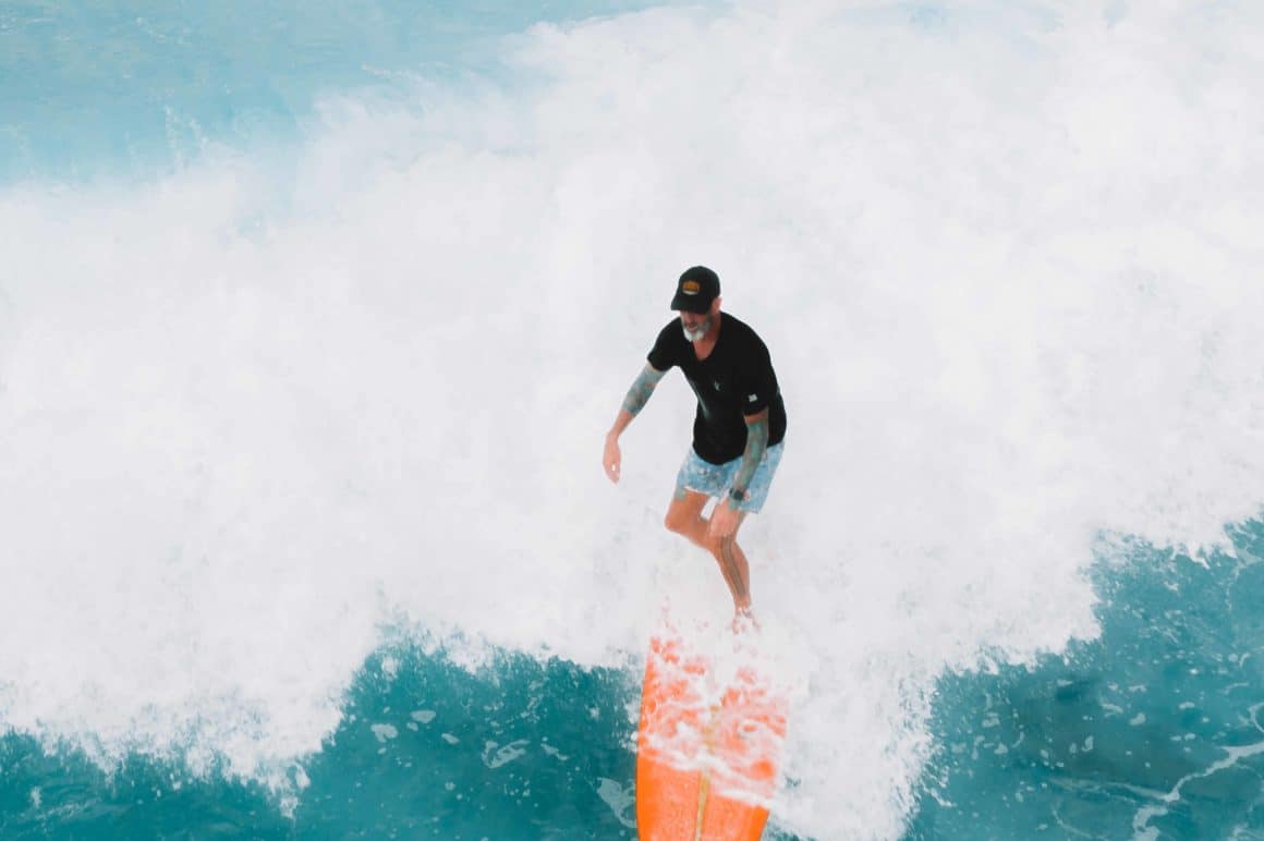 Man on orange surfboard on holiday
